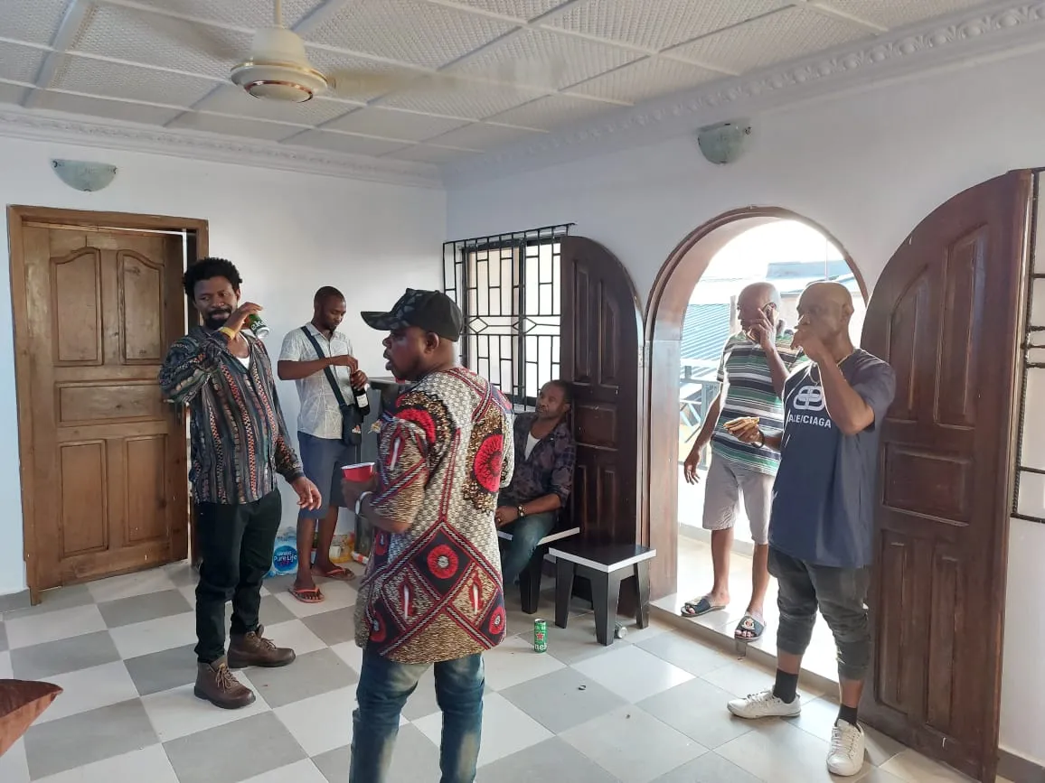 Residents and staff talking together in the tiled hallway of the shelter in Lagos