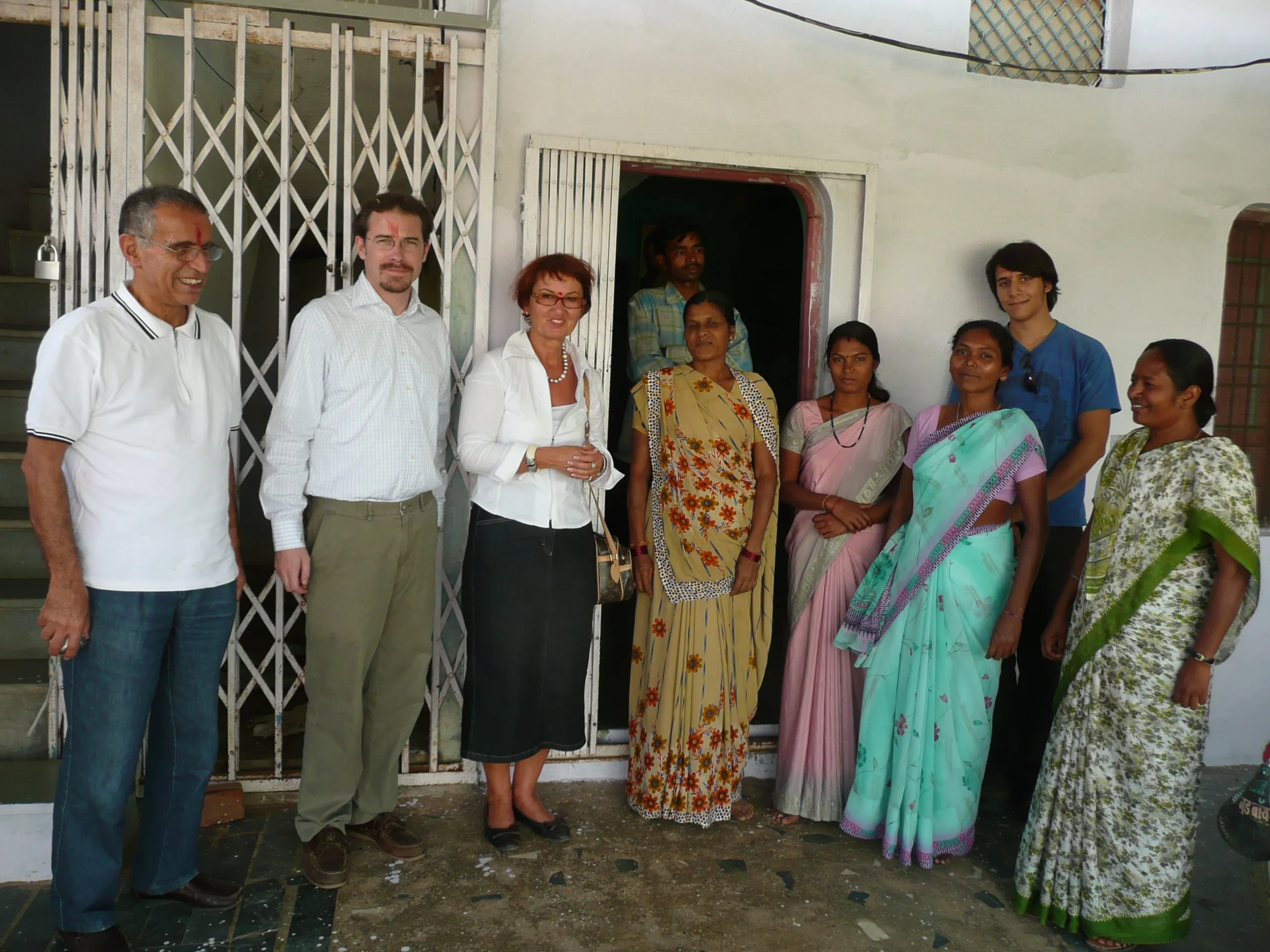 Visitors and staff standing together outside the school building