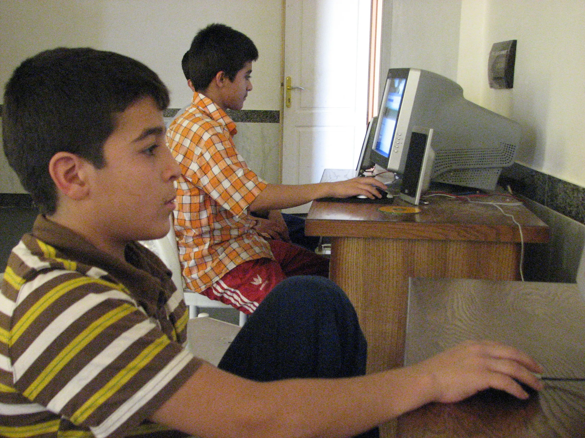 Two boys working at desktop computers at the education centre