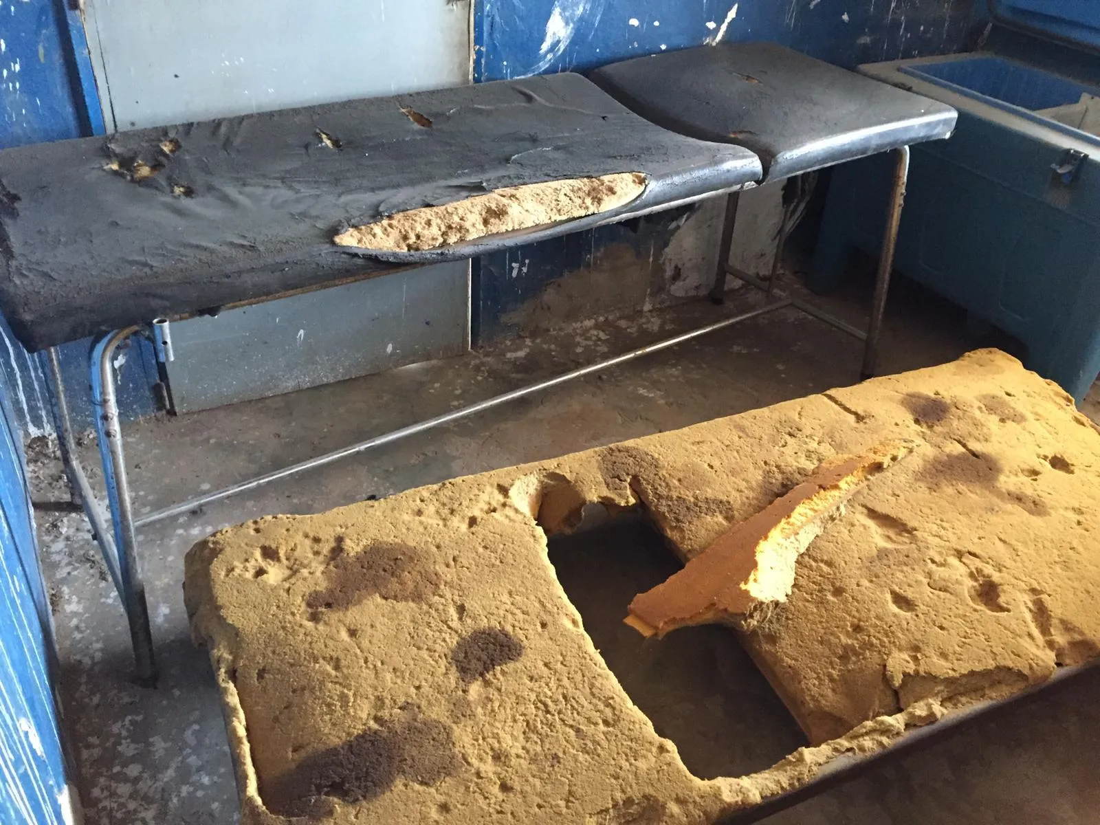 The delivery room before renovation: examination couches with torn and crumbling foam mattresses