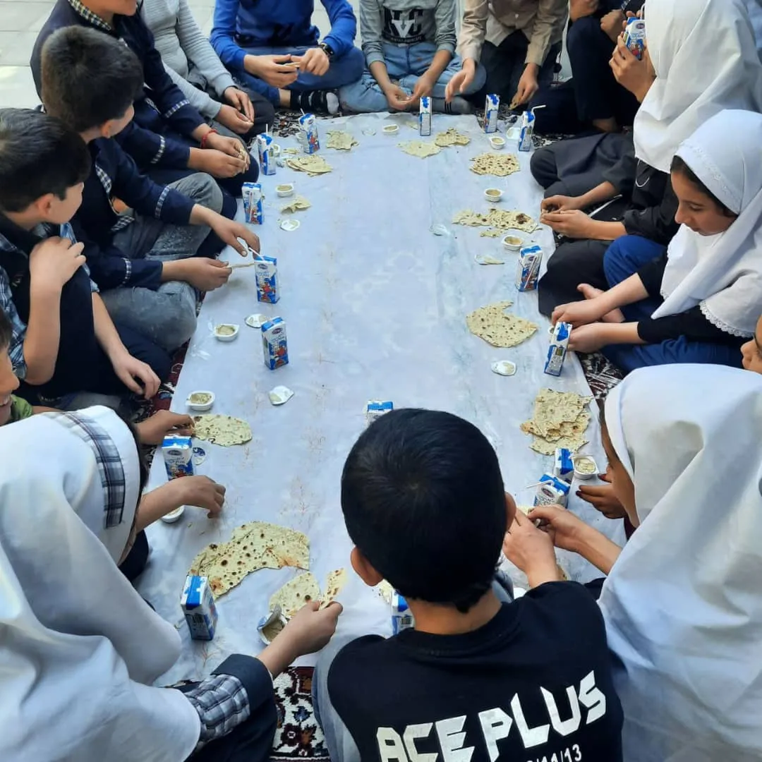 Kids sitting on the floor having juice and bread