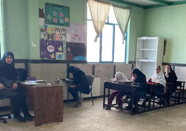 School girls sitting in a classroom with their teacher