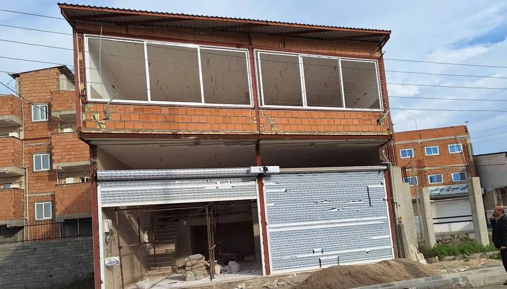 The two-storey building being fitted out, its upper floor glazed and the ground floor still a shell